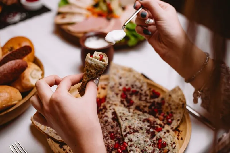 Girl holding rolled slice of food
